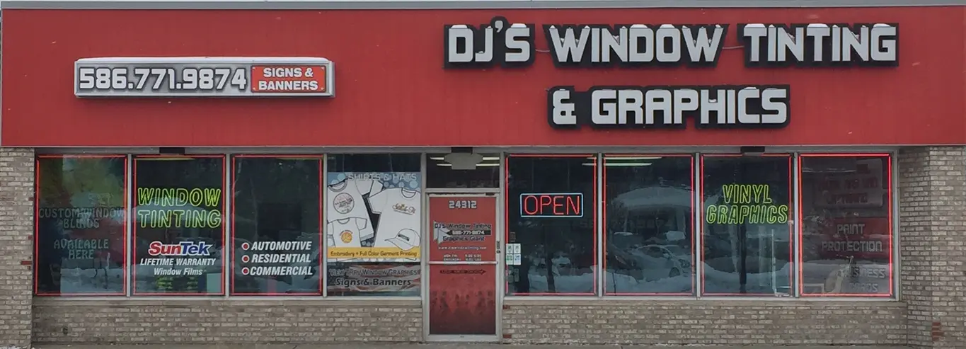 A red and white sign is in front of the window shop.