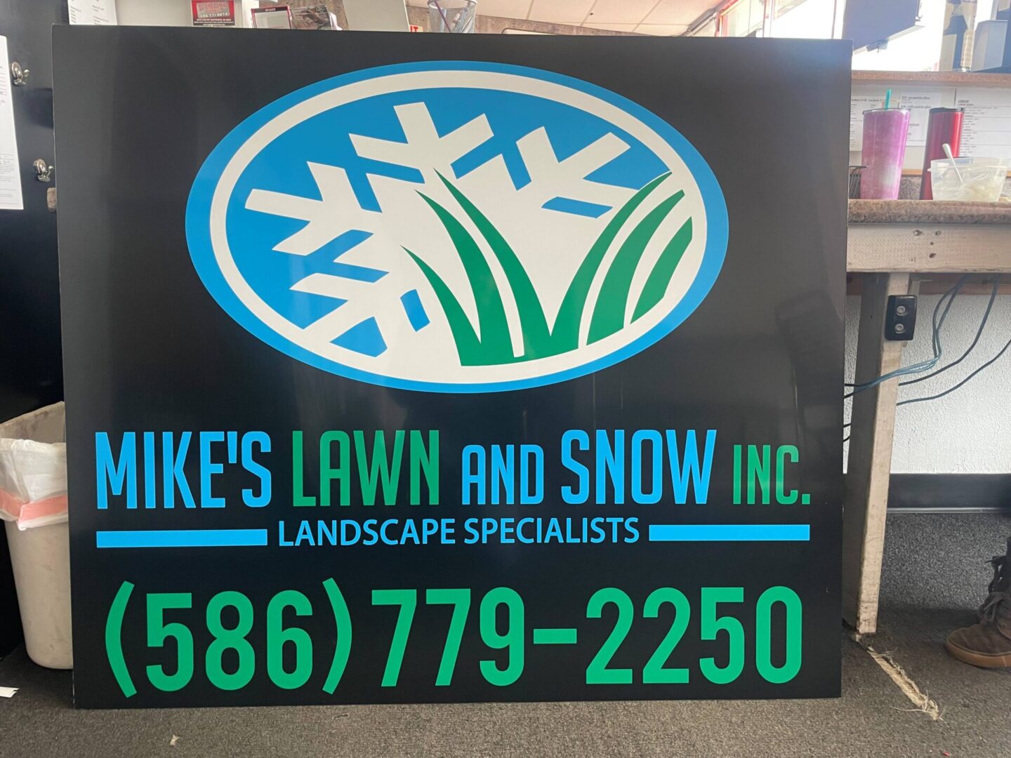 A sign that is advertising for mike 's lawn and snow.