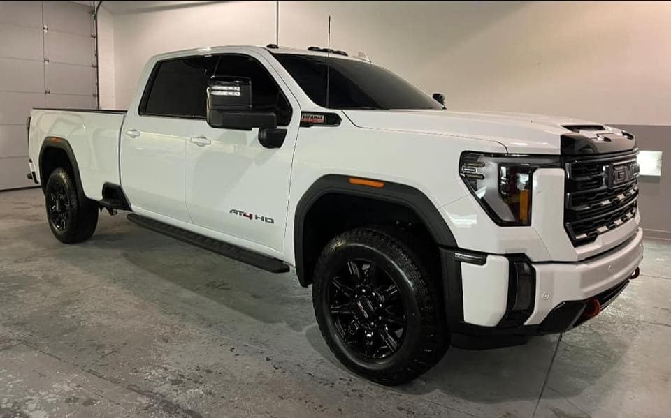 A white truck parked in a garage with its door open.